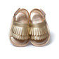 Gold metallic fringed baby sandals with hook-and-loop ankle straps, front view