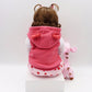 Baby girl silicone doll from back view in pink hooded jacket with white patterned hem and plush toy