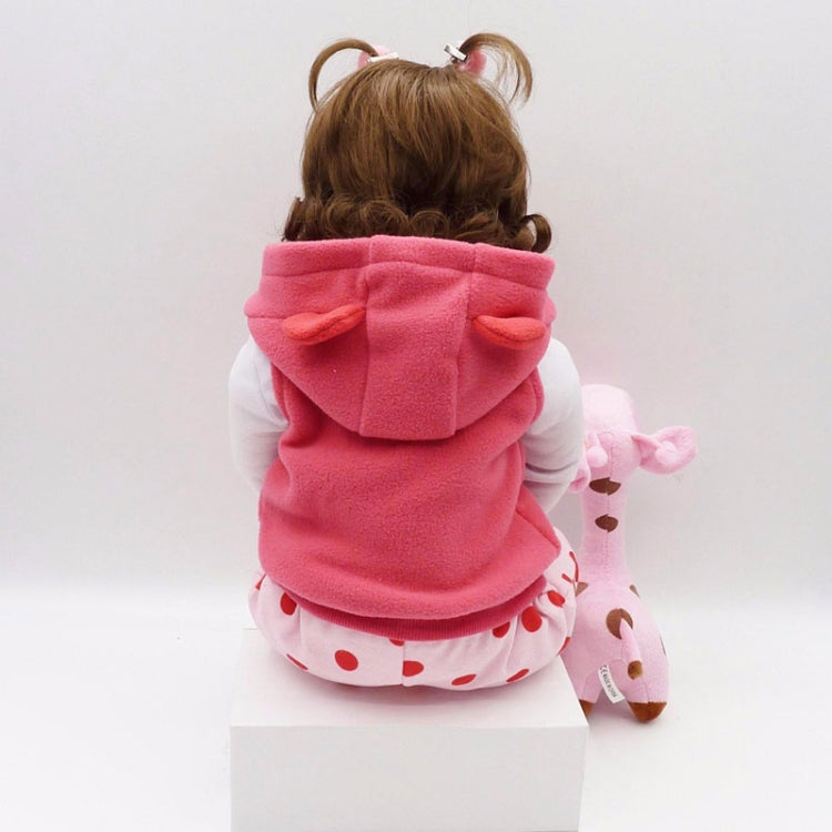 Baby girl silicone doll from back view in pink hooded jacket with white patterned hem and plush toy