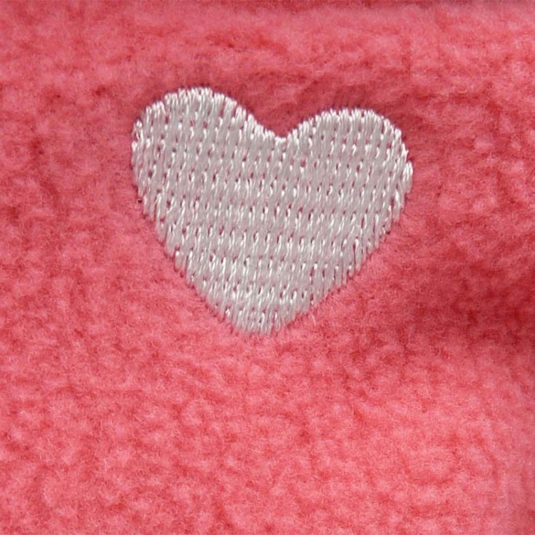 Pink fabric with white heart embroidery detail on the doll’s clothing