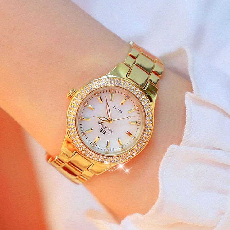 Women’s gold-tone round watch with white dial, sparkling bezel, and metal link strap