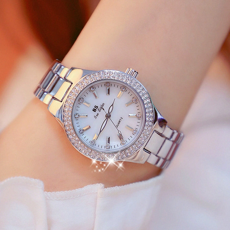 Women’s silver-tone round watch with white dial, jeweled bezel, and metal link bracelet