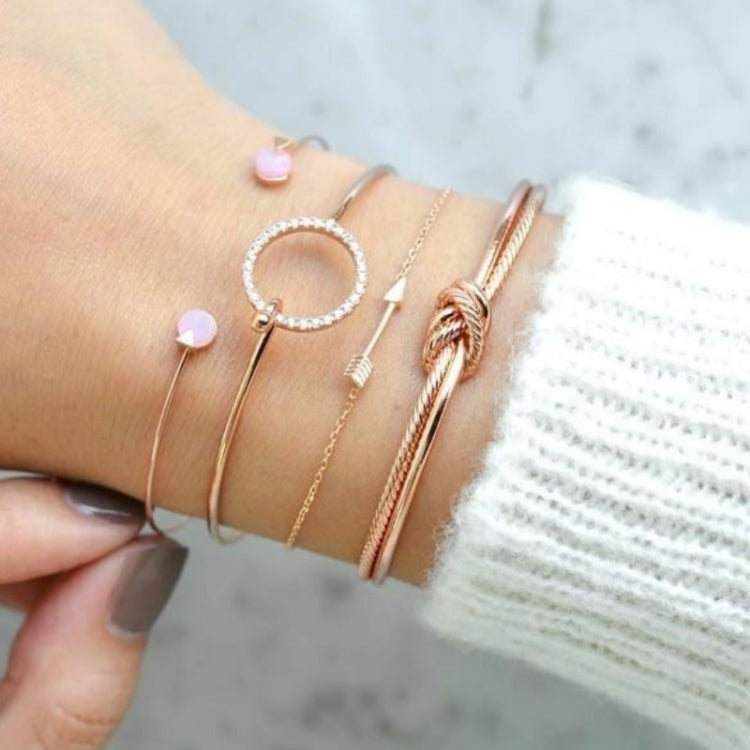 Bracelet set on wrist: thin gold chains with crystal hoop and pink charm links