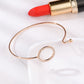 Rose-gold open cuff bracelet with crystal circle ring and small clasp charm