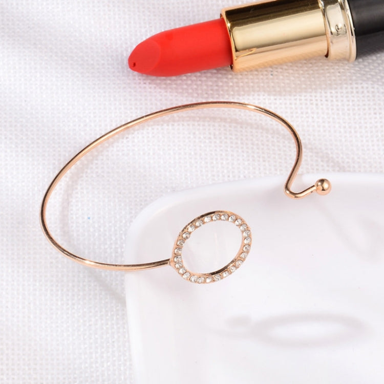 Rose-gold open cuff bracelet with crystal circle ring and small clasp charm