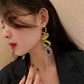 Gold-tone oval gemstone drop earrings in red, yellow, green, and purple