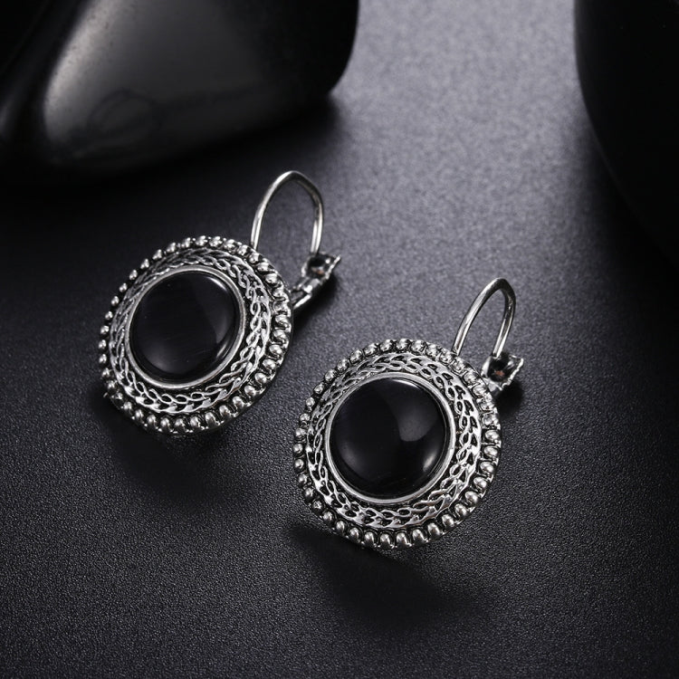 Round black stone drop earrings with ornate silver border and slender lever-back hooks