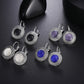 Assorted round drop earrings with ornate silver frames in black, white, purple, blue