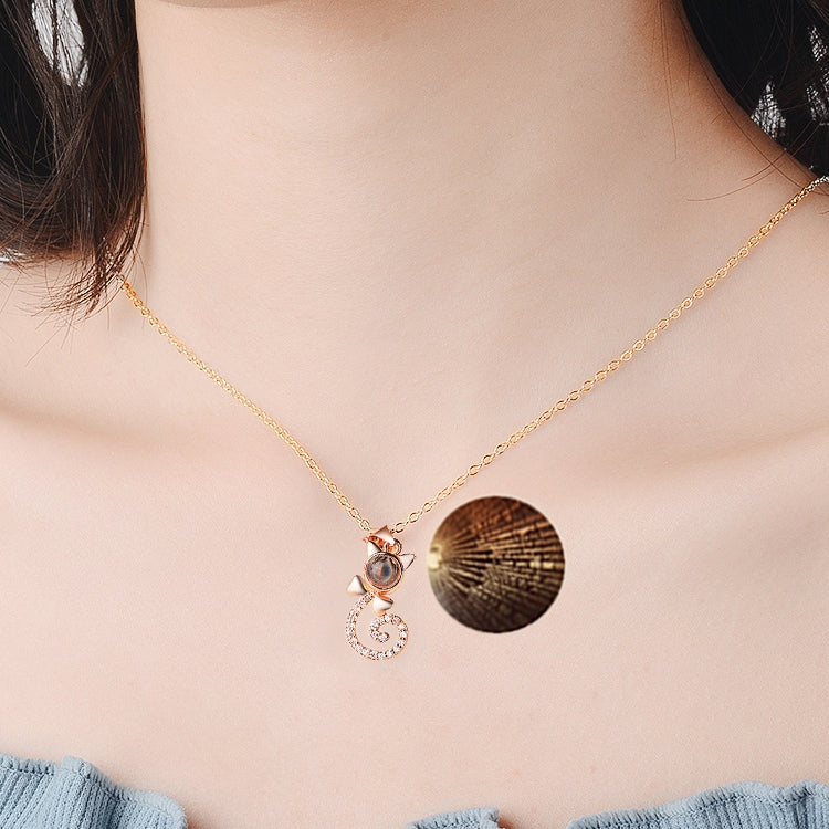 Rose gold projection pendant necklace with round disc and heart swirl charm, crystal accents