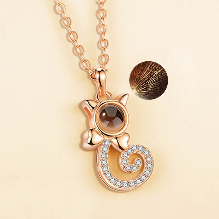 Rose gold projection pendant necklace with round dark disc, cat-ear accents, heart swirl charm