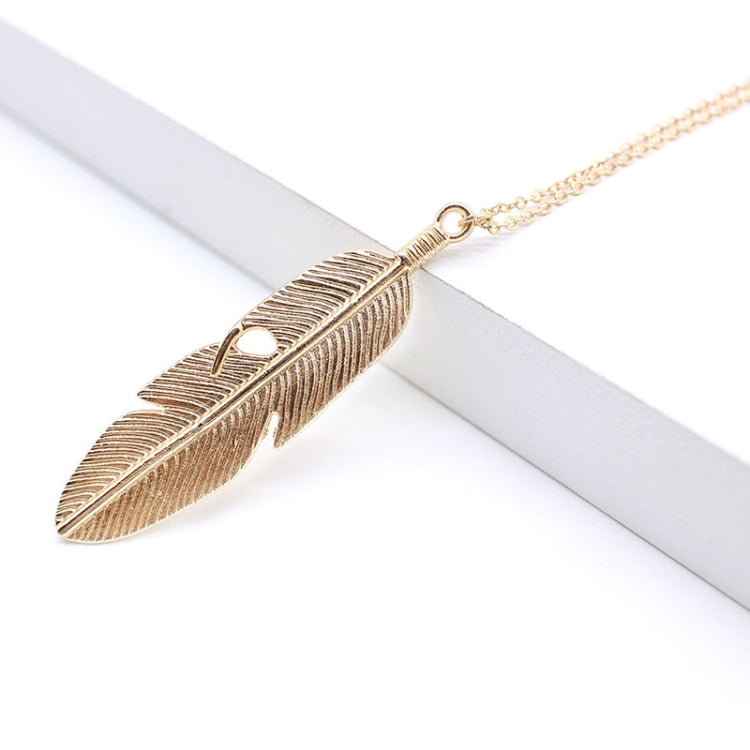 Gold feather pendant necklace with textured feather charm on thin chain