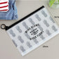 Transparent PVC cosmetic bag with gray pineapple print, black zipper, wrist loop, flat lay