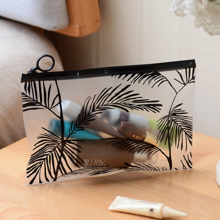 Transparent PVC makeup pouch with black zipper and palm leaf print, clear front display