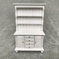 White mini dollhouse cabinet bookcase with open shelves and central drawer unit