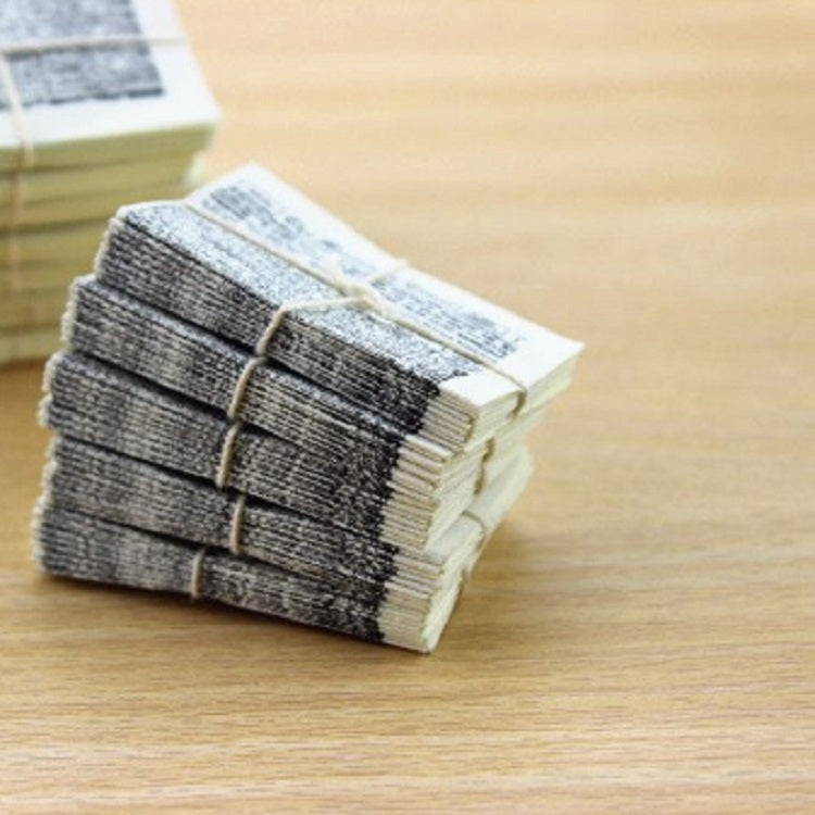 Miniature newspaper bundle with multiple gray stacks, tied with string