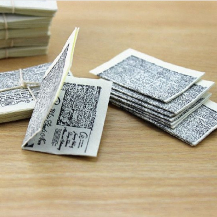 Miniature newspaper pages and bundles, some folded open, gray printed pages