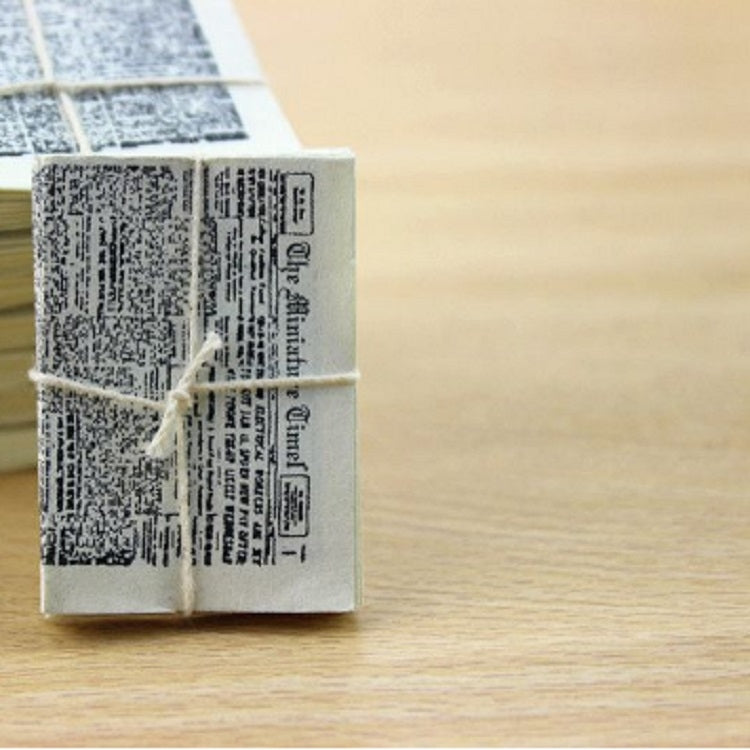 Miniature newspaper bundle stack with gray text print on folded pages
