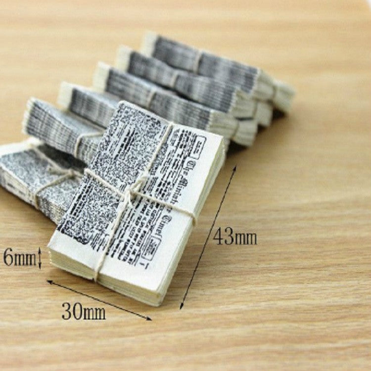 Miniature newspaper bundle with twine, size marked 30mm and 43mm
