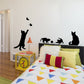 Cat wall sticker silhouettes with butterflies on wall near bed and furniture