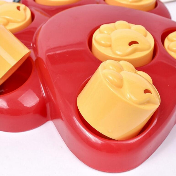 Close-up of red paw slow feeder bowl with yellow bear-face treat blocks