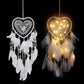 Heart dream catchers: one white without lights, one glowing with warm string lights and feathers