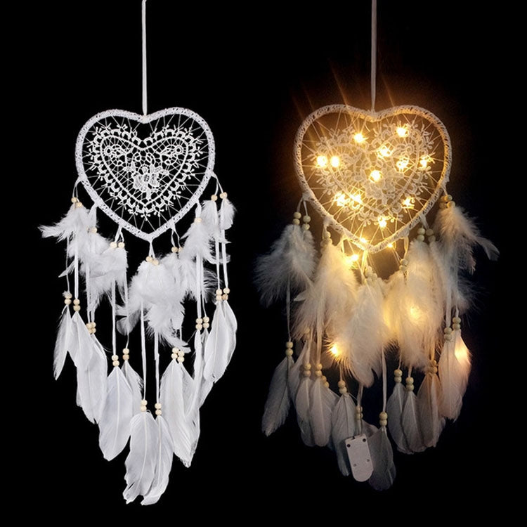 Heart dream catchers: one white without lights, one glowing with warm string lights and feathers