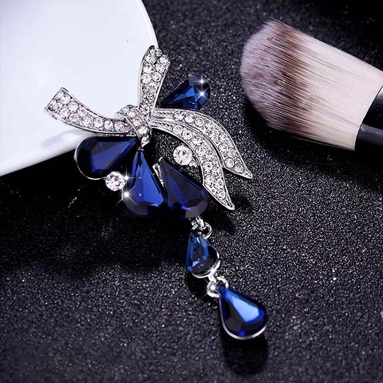 Rhinestone butterfly knot brooch with blue teardrop dangles in silver-tone setting