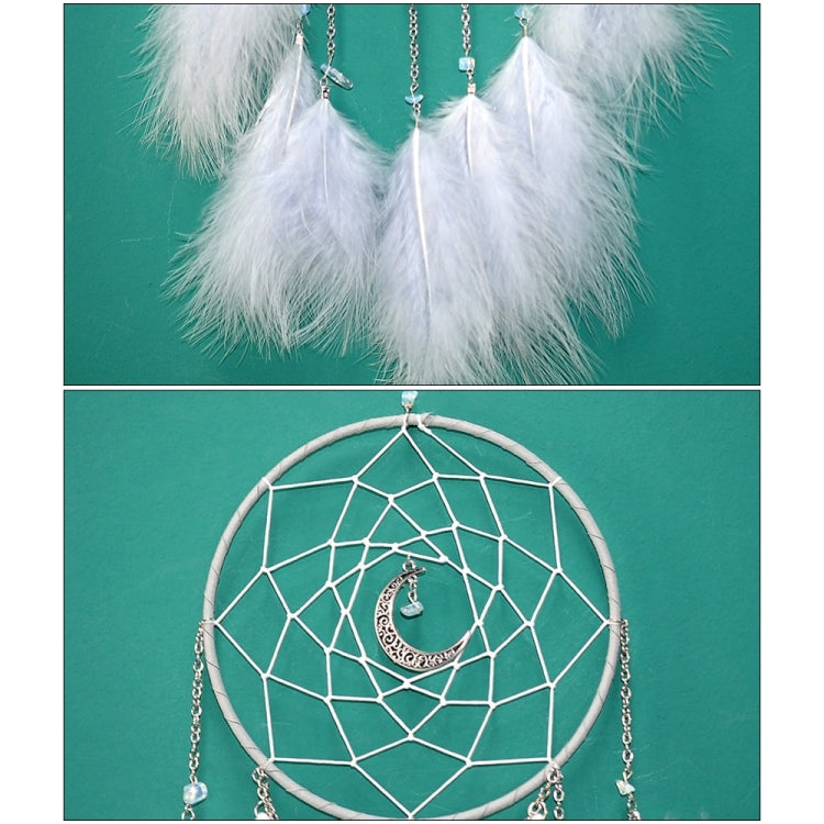 Close-up of white feather dream catcher wall hanging with web hoop and silver dangling chains