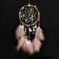 Pink dream catcher wall hanging with hoop web, dangling chains, feather fringe, and warm string lights