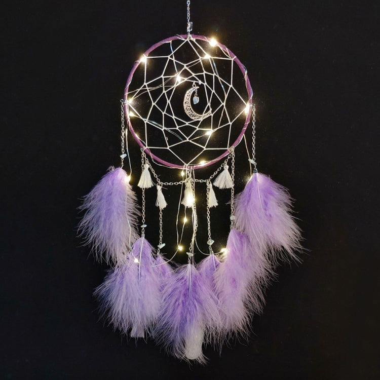 Purple feather dream catcher wall hanging with web hoop, dangling chains, and warm string lights