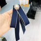 Navy pearl rhinestone bow-knot brooch with faux pearl center and ribbon streamers