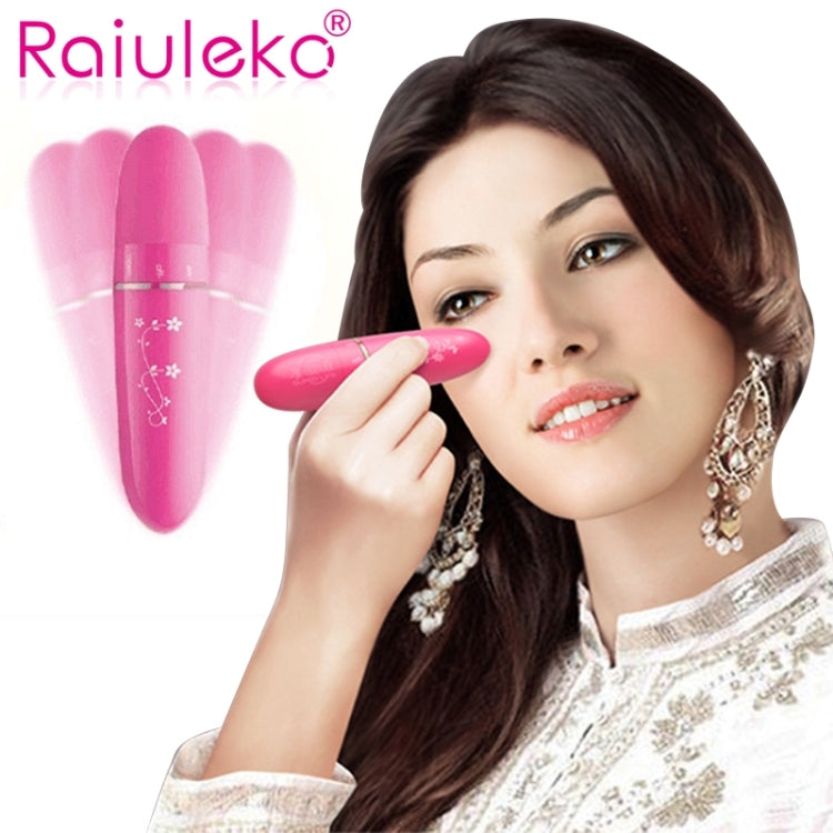 Pink mini electric eye massager held near eye on a model for under-eye care