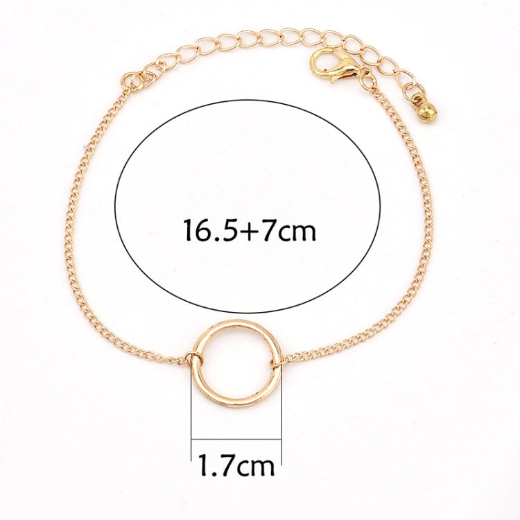 Gold-tone chain bracelet with oval ring knot detail and bar clasp, flat lay