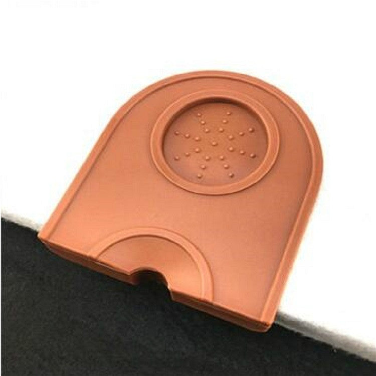 Brown/orange corner coffee pad close-up with raised circular textured insert.