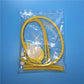 Yellow stethoscope toy parts in clear bag with tubing and chest piece