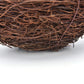 Close-up of brown woven rattan nest bowl with loose straw fibers