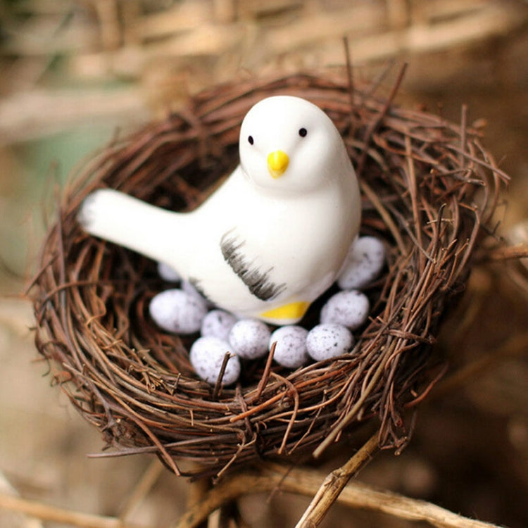 Rattan bird nest with white chick figurine and speckled white eggs
