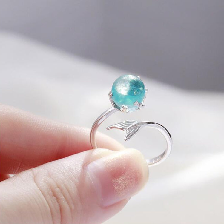 Close-up of silver open ring with round turquoise crystal and fish-tail accent