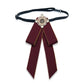 Maroon bow-knot accessory with pearl cluster center and long ribbon tails on black strap