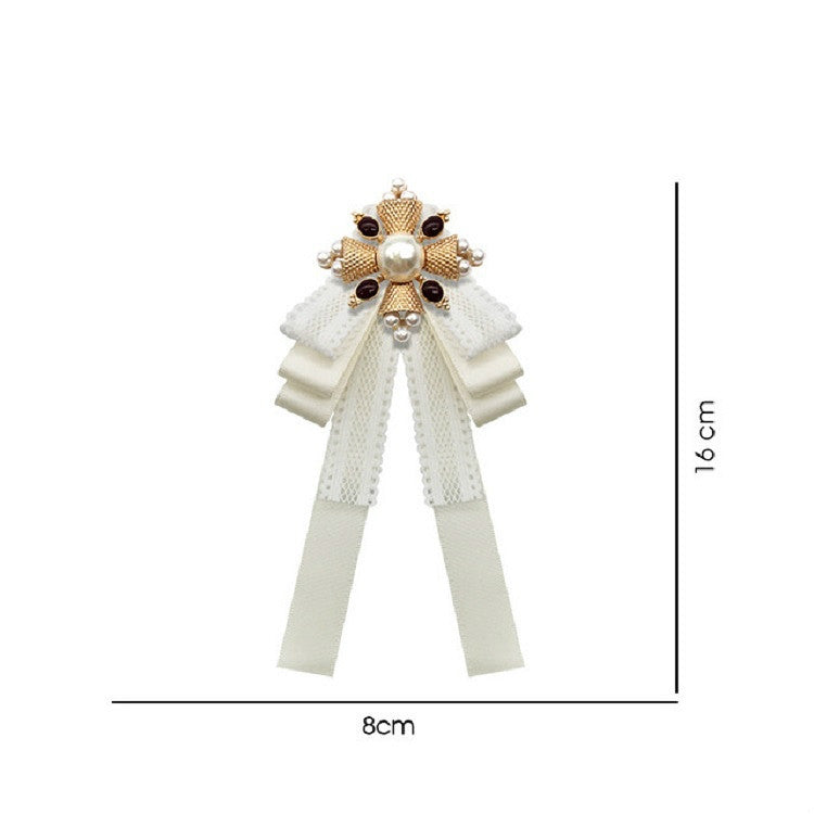 Ivory lace bow brooch with pearl centerpiece, gold and bead details, and ribbon streamers