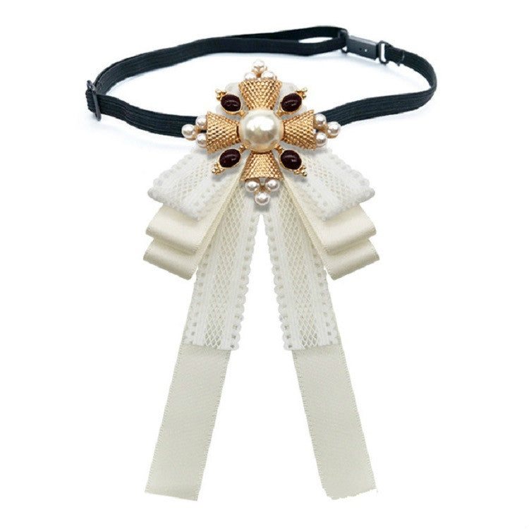 Black lace bow accessory on a dark choker strap with pearl center and gold beads