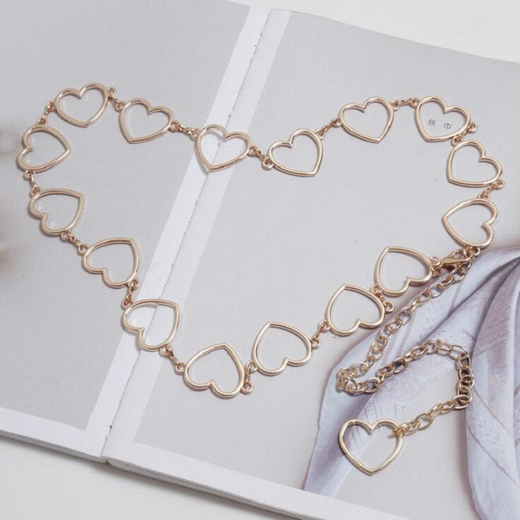 Gold-tone heart-link waist chain with heart ring links and layered dangling charms