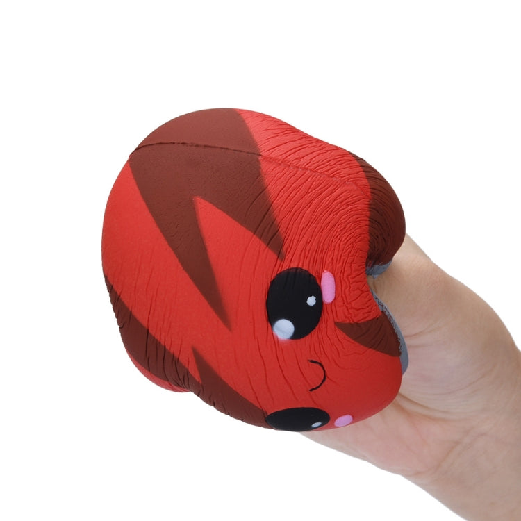 Close-up of red lightning-pattern squishy can toy with gray lid and face