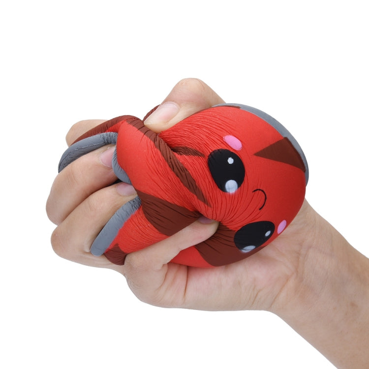 Red squishy can toy being squeezed; gray lid and cute face visible