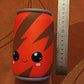 Red squishy can toy with measuring ruler beside it