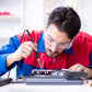 Soldering iron in use by a technician working on an electronics circuit board