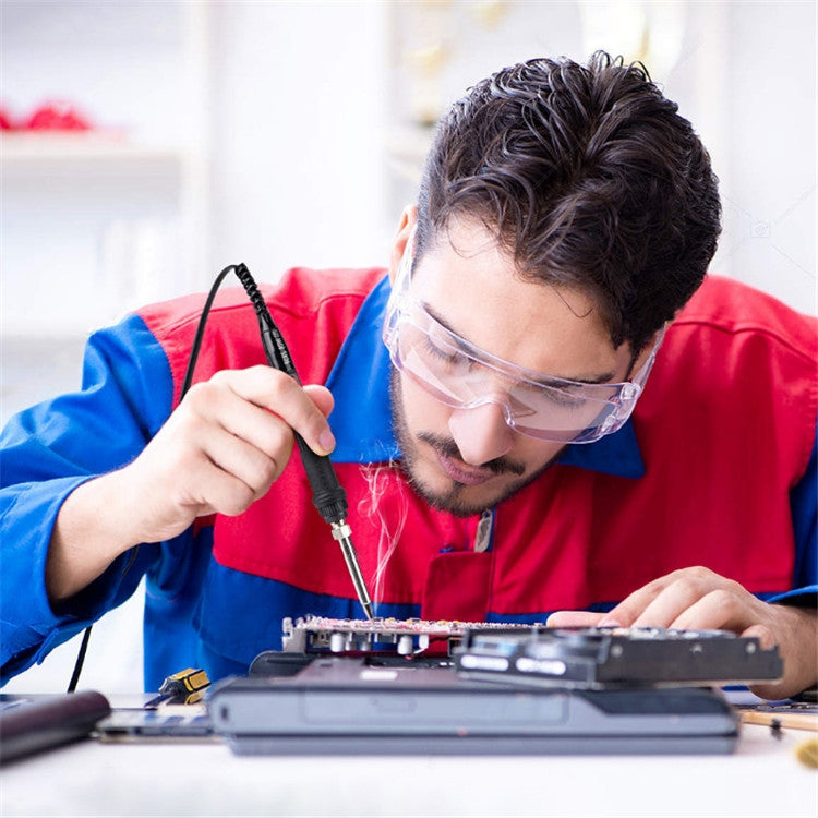 Soldering iron in use by a technician working on an electronics circuit board