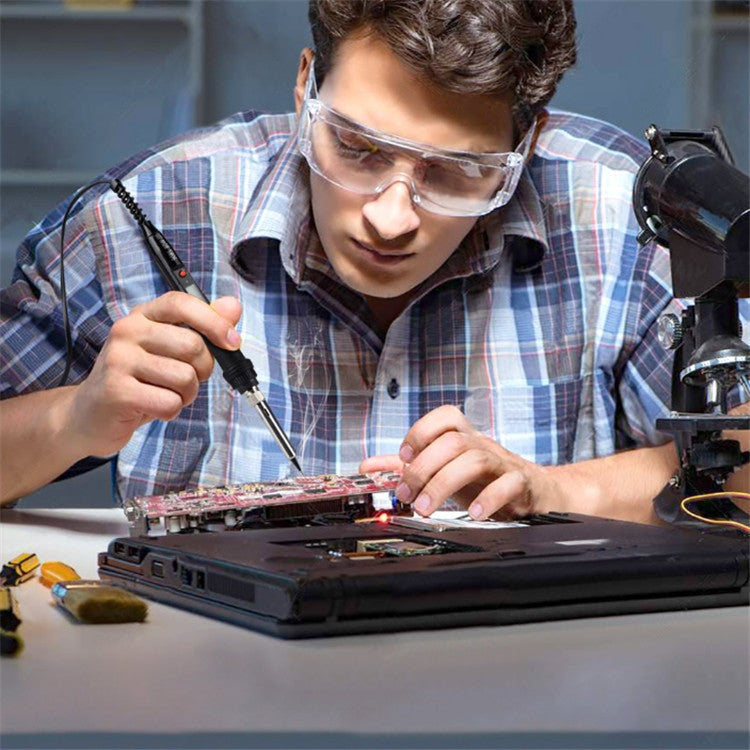 Soldering iron being used to solder components on a laptop-style circuit board