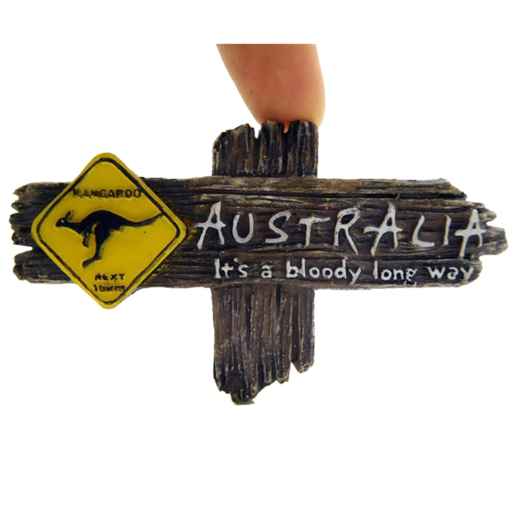 Kangaroo Australia fridge magnet held by fingers, dark wood sign with kangaroo badge