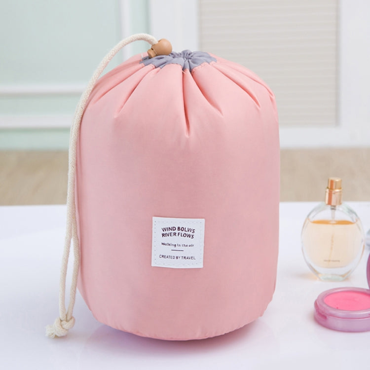 Pink cylindrical drawstring wash bag with braided rope handle and front label